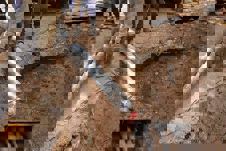 a hole in the ground, revealing pipes