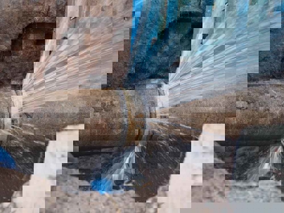 a pipe is burst and gushing water.