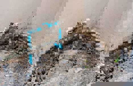 blue pipes installed in front of a concrete wall