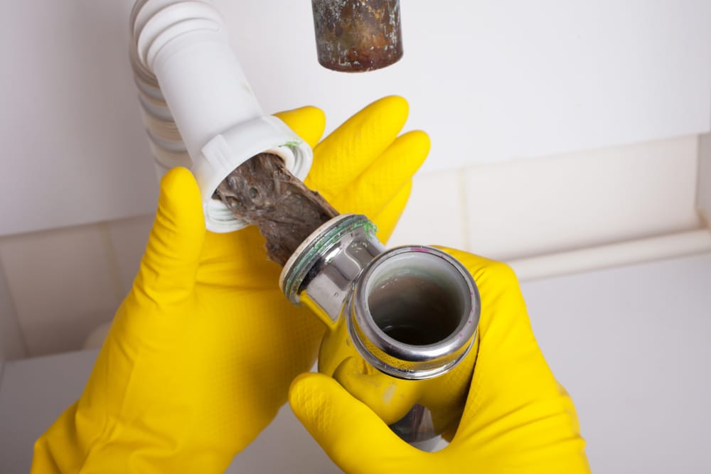 plumber unclogging a drain