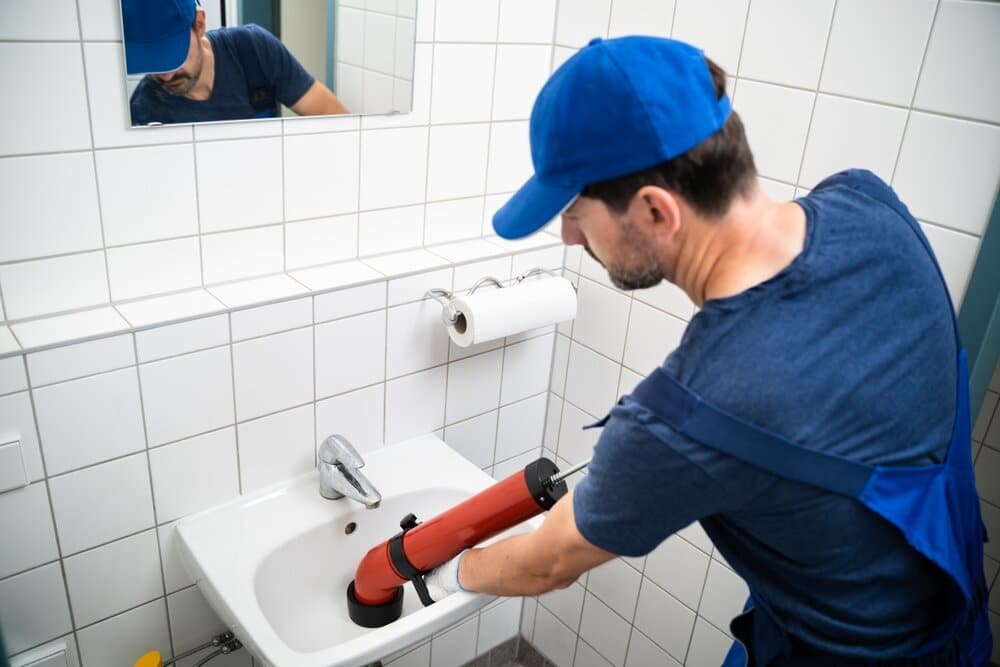 a plumber cleaning a drain
